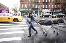 Alisha Narvaez Manager at International Funeral & Cremation Services transports a body to the funeral home on April 24, 2020 in the Harlem neighborhood of New York City. - For many families already in distress, finding a funeral home in New York that will accept the body of a loved one is a headache; in Harlem, International Funeral home tries not to turn anyone away, even if it means being under stress. AFP/Johannes Eisele 