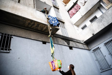 An inhabitant of the residence Maison Blanche (White House residence), composed of 226 mostly unsanitary dwellings, collects food offered by neighbours from his balcony, using a rope made with blankets, on March 31, 2020, in Marseille, southern France, on the fifteenth day of a lockdown aimed at curbing the spread of the COVID-19 (novel coronavirus). AFP/Anne-Christine Poujoulat