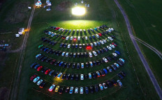 An aerial view shows cinema goers sitting in their cars parked at a drive-in cinema in Marl, western Germany, on April 6, 2020, one of the few entertainments still allowed due to the spread of the novel coronavirus COVID-19. AFP/Ina Fassbender 