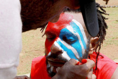 Justice seekers: A Papuan Students Alliance (AMP) member has his face painted with the colors of the Bintang Kejora (Morning Star) flag during a protest on Jl Medan Merdeka Barat, Central Jakarta on Nov. 16. The protesters demanded that the government thoroughly investigate the killing of Papuan pastor Yeremia Zanambani in Intan Jaya, Papua, and withdraw military and police personnel from the country’s easternmost province. JP/ Dhoni Setiawan