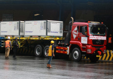 Workers unload containers carrying the Sinovac vaccine for COVID-19 under National Police security at Soekarno-Hatta International Airport in Tangerang, Banten, on Dec. 31, 2020. As many as 1.8 million doses of Chinese firm Sinovac Biotech's COVID-19 vaccine, CoronaVac, arrived in Indonesia as the government eyes to roll out vaccination for medical workers in January.