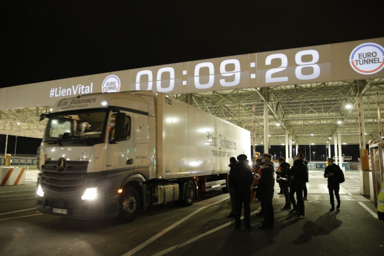 Frech custom offciers watch the first vehicle entering the Eurotunnel terminal post Brexit, an Estonian lorry driver, on January 1, 2021, in Coquelles, northern France. Britain on Thursday finally severed its turbulent half-century partnership with Europe, quitting the EU single market and customs union and going its own way four-and-a-half years after its shock vote to leave the bloc. Brexit, which has dominated politics on both sides of the Channel since 2016, became a reality as Big Ben struck 11:00 pm (2300 GMT) in London, just as most of mainland Europe ushered in 2021.