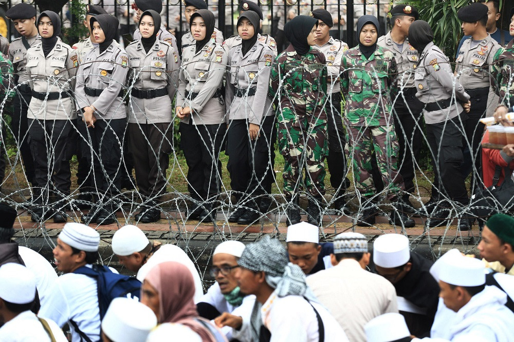 Ladies first: Women police and military personnel line up outside the Jakarta Police headquarters as hundreds of members of the Islam Defenders Front (FPI) rallied in a show of support for FPI leader Rizieq Shihab, who was undergoing questioning on Feb. 1, 2017. The government has banned the FPI.