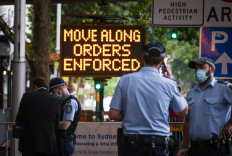 New South Wales police officers guard an entrance as part of COVID-19 restrictions for New Year celebrations around Circular Quay in central Sydney on Dec. 31, 2020.
