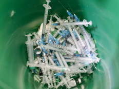Dirscarded syringes, used to adminster the COVID-19 vaccine, are pictured inside a waste container at Clalit Health Services, in the northern Arab Israeli city of Umm al Fahm , on January 4, 2021. - Israel said Sunday two million people will have received a two-dose Covid-19 vaccination by the end of January, a pace Prime Minister Benjamin Netanyahu boasts is the world's fastest. Health Ministry Director General Hezi Levy said that because of the enthusiastic takeup, Israel would be easing the speed of vaccination to eke out stocks. 