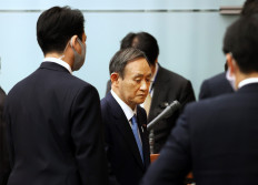 Japan's Prime Minister Yoshihide Suga leaves after a press conference at his official residence in Tokyo on Monday. Suga said he was considering declaring a state of emergency in the greater Tokyo area over a 