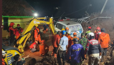 Rescue workers use heavy equipment to rescue survivors of a landslide in West Java on Jan. 9, 2020.