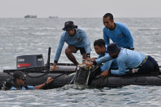 Indonesian Navy divers recover wreckage from Sriwijaya Air flight SJ182 during a search and rescue operation near Lancang island, Thousand Islands regency, on Jan. 10, 2021, the day after the Boeing 737-500 crashed shortly after takeoff from Soekarno-Hatta International Airport.