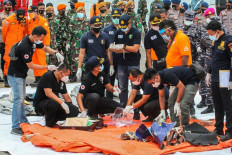 Rescue workers inspect recovered items and debris at the port in Jakarta on January 10, 2021, during the search operation for Sriwijaya Air flight SJY182 which crashed after takeoff from Jakarta on January 9. 
