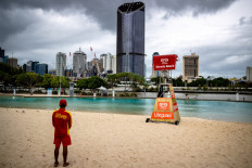 A lifeguard stands watch over a deserted South Bank beach on the first day of a snap lockdown in Brisbane on Jan. 9, 2021. 