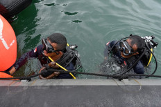 Navy divers prepare to go under during recovery operations for the ill-fated Sriwijaya Air Boeing 737-500 passenger aircraft near Lancang Island on January 10, 2021, following the January 9 crash of flight SJ182 into the Java Sea minutes after takeoff. 