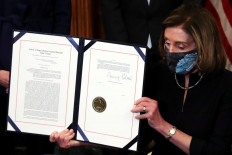 US House Speaker Nancy Pelosi (D-CA) shows the article of impeachment against US President Donald Trump after signing it in an engrossment ceremony, at the US Capitol in Washington January 13, 2021. 