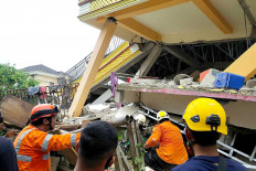 Rescuers search for survivors trapped in a collapsed building in Mamuju, West Sulawesi, on Jan. 15, after a 6.2-magnitude earthquake shook the province.