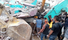 Rescuers search for survivors in a collapsed building in Mamuju city on Jan. 15, 2021, after a 6.2-magnitude earthquake rocked Indonesia's Sulawesi island.