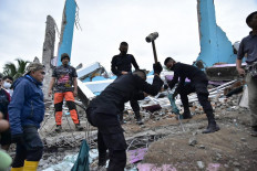 Rescuers search for survivors at the Mitra Manakarra hospital in Mamuju city on Jan. 15, where as many as 20 patients and staff are trapped beneath the rubble after the hospital was flattened by a 6.2-magnitude earthquake.