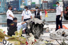 Officers from the National Transportation Safety Committee (KNKT) inspect part of a turbine recovered from Sriwijaya Air flight SJ182 on Wednesday at the Jakarta International Container Terminal in North Jakarta. 
