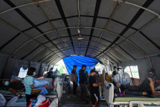 The general view shows patients receiving care at a makeshift ward outside a regional hospital building due to concerns of aftershocks in Mamuju on January 17, 2021, following the 6.2 magnitude earthquake which hit early on January 15. 