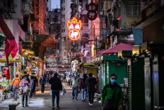 Pedestrians walk on a street in the Jordan district of Kowloon in Hong Kong on January 20, 2021. 