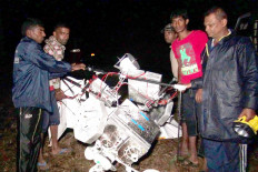 Sri Lankan men at a tea plantation look at the wreckage of a Google balloon that crashed in the central part of the country in Gampola on February 17, 2016. Google's A Google balloon, part of the company's high-speed Internet service known as 