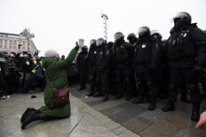 A woman holding an icon kneels in front of a group of riot police during a rally in support of jailed opposition leader Alexei Navalny in downtown Moscow on January 23, 2021. Navalny, 44, was detained last Sunday upon returning to Moscow after five months in Germany recovering from a near-fatal poisoning with a nerve agent and later jailed for 30 days while awaiting trial for violating a suspended sentence he was handed in 2014.