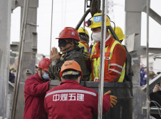 One of twenty-two Chinese miners wearing a black patch is saved from hundreds of meters underground, where they had been trapped for two weeks after a gold mine explosion in Qixia, in eastern China's Shandong province on January 24, 2021.