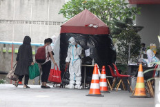 Speedy recovery: Several COVID-19 carriers are sprayed off with disinfectant prior to entering an isolation facility at a hotel on Jl. Kramat Raya in Central Jakarta, on Saturday. 