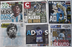 View of front pages of newspapers displayed in a stand in Lima with the news of Argentinian football legend Diego Armando Maradona's death, on November 26, 2020. Argentine football legend Diego Maradona who died of a heart attack Wednesday at the age of 60, will be buried Thursday in the Jardin de Paz cemetery on the outskirts of Buenos Aires, a spokesman said. 