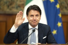 In this file handout photo taken on November 19, 2020, in Rome oand released by the Italian Prime Minister's press office, Prime Minister Giuseppe Conte waves during a video conference meeting with members of the European Council on the EU response to the COVID-19 pandemic.