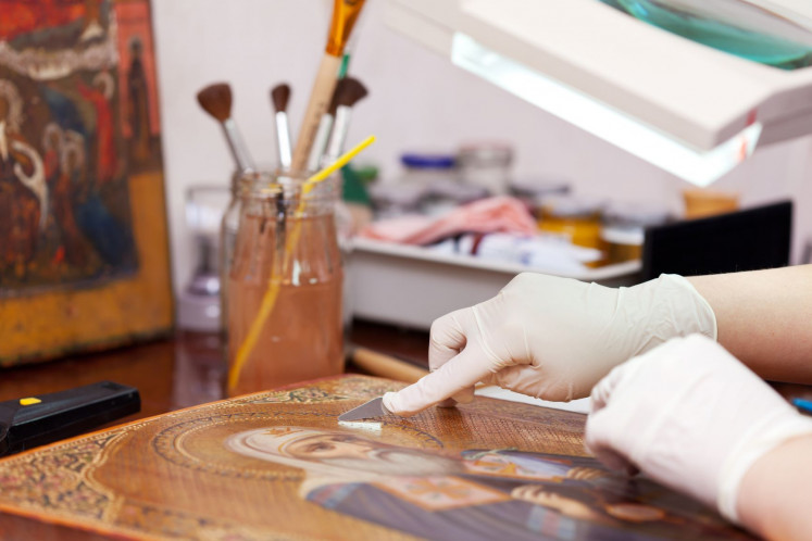 Light touch: An art restorer works on an old icon with a spatula at a restoration workshop.