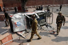 Policemen walk past a damaged police vehicle outside the historic Red Fort after Tuesday's clashes between police and farmers, in the old quarters of Delhi, India, January 27, 2021. 