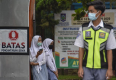 Female high school students stand next to a school's gate at a high school in Mataram, West Nusa Tenggara on Jan. 18, 2020.