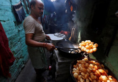 A vendor fries "paani puri", a traditional Indian snack, in an alley at a slum area in Kolkata, India Feb. 16, 2017.