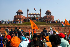 Protesters stand on the ramparts of Red Fort as farmers continue to protest against the central government's recent agricultural reforms in New Delhi on January 26, 2021.
