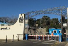A security agent walks at the entrance of Olympique de Marseille' Robert-Louis-Dreyfus training centre (formally known as La Commanderie) in Marseille, southeastern France, on January 31, 2021, the morning after angry fans broke in. Eighteen people were still in police custody on January 31 after the violent incidents that took place in La Commanderie. Some 300 fans gathered on January 30 in front of the gates of the training center with banners reading 'Heads of the club: resign'.