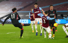 Liverpool's Egyptian midfielder Mohamed Salah (left) scores the opening goal during the English Premier League football match between West Ham United and Liverpool at The London Stadium, in east London on January 31, 2021.
