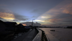 Sunlight streaks through the clouds above Kampung Beting, a floating settlement in Pontianak, West Kalimantan.