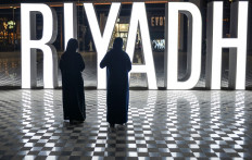 Women stand before a lit "I LOVE RIYADH" sign at a shopping centre in Saudi Arabia's capital Riyadh on October 31, 2020.
