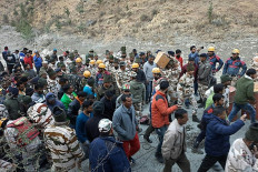 This handout photo taken on February 7, 2021 and released by the Indo-Tibetan Border Police (ITBP) shows onlookers and members of the Indo-Tibetan Border Police (ITBP) during a rescue operation after a broken glacier caused a major river surge that swept away bridges and roads, at Reni village in Chamoli district of Uttarakhand. Three people were confirmed dead and at least 150 were missing in northern India after a broken glacier caused a major river surge that swept away bridges and roads on February 7, police said.