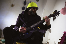 Srdjan Sarovic, visual artist and a war veteran, plays on a guitar made out of M70 rifle and a helmet, made by Serbian sculptor Nikola Macura at his studio, in Novi Sad