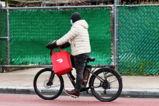 A Doordash delivery person rides their bike on Church Avenue in the Flatbush neighborhood of Brooklyn on December 04, 2020 in New York City. Food delivery startup DoorDash Inc is expected to raise its U.S. initial public offering up to $3.14 billion. 
