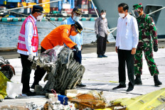 This handout picture taken and released on January 20, 2021 by Indonesia's Presidential Palace shows Indonesian President Joko Widodo (2nd right) visiting a port in Jakarta, where recovered wreckage and human remains from the ill-fated Sriwijaya Air flight SJ182 are being collected from the crash scene.