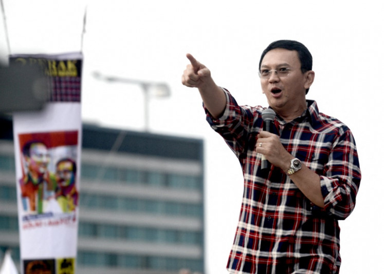 Chinese-Indonesian governor Basuki Tjahaja Purnama gestures to his supporters at his final campaign rally prior to the gubernatorial election in Jakarta on February 11, 2017.