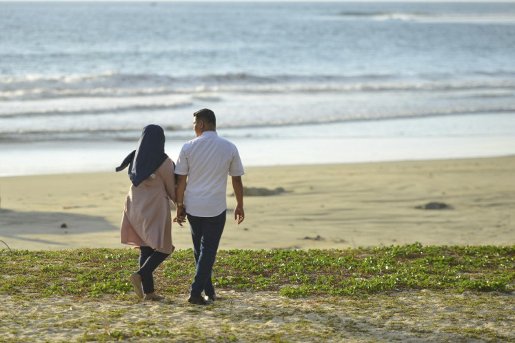 A couple walks at Lhoknga beach on Valentine's Day, Aceh province on Feb. 14, 2020. 

