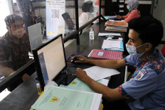A State Land Agency (BPN) official assists a resident with his land certificate at the Dumai Land Agency office in Riau on Feb. 11, 2021. The Agrarian and Spatial Planning Ministry is planning to use electronic land certificates for simpler and more secure land registration.