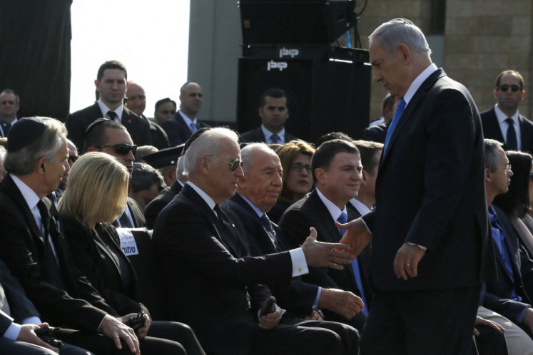 Israeli Prime Minister Benjamin Netanyahu shakes hands with US Vice President Joe Biden during a state memorial service for former Israeli prime minister Ariel Sharon outside the Knesset (Israeli Parliament) in Jerusalem, on January 13, 2014. US President Barack Obama led US tributes to the late Israeli premier, who died on January 11 at the age of 85 after spending eight years in a coma that struck him at the height of a decades-long career which saw him lauded as a military hero and statesman, but also reviled as a warmongering criminal. Obama remembered Sharon as 