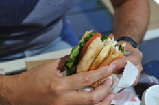 A man eats a chicken sandwich at a McDonald's restaurant in Oak Brook, Illinois on July 21, 2015. 