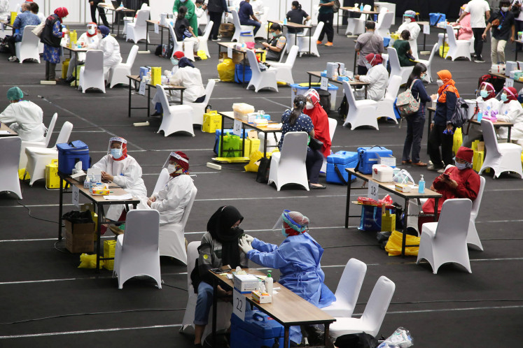 Medical workers undergo mass vaccination at the Senayan sports complex in Central Jakarta, on Feb. 4. Questions have emerged about priority recipients of the vaccine at a time when supplies are still scarce.