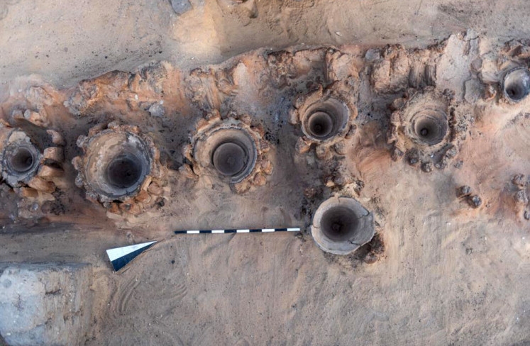 A handout picture released by the Egyptian Ministry of Tourism and Antiquities on February 13, 2021, shows the remains of a row of vats used for beer fermentation, in a complex which may be the world's 