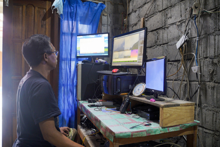 Agus Sarnyoto, coordinator of Posko Induk Balerante, runs the livestream broadcast from the
studio in his house.