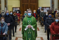 Don Giuseppe Corbari, parson of the Church of Robbiano, poses for a photograph with worshippers in Robbiano in Giussano, Lombardy, on February 16, 2021. On Feb. 21, Italy's Lombardy region will mark one year since it recorded the first locally acquired case of Covid-19 in Codogno, in what became the first major outbreak in Europe. 